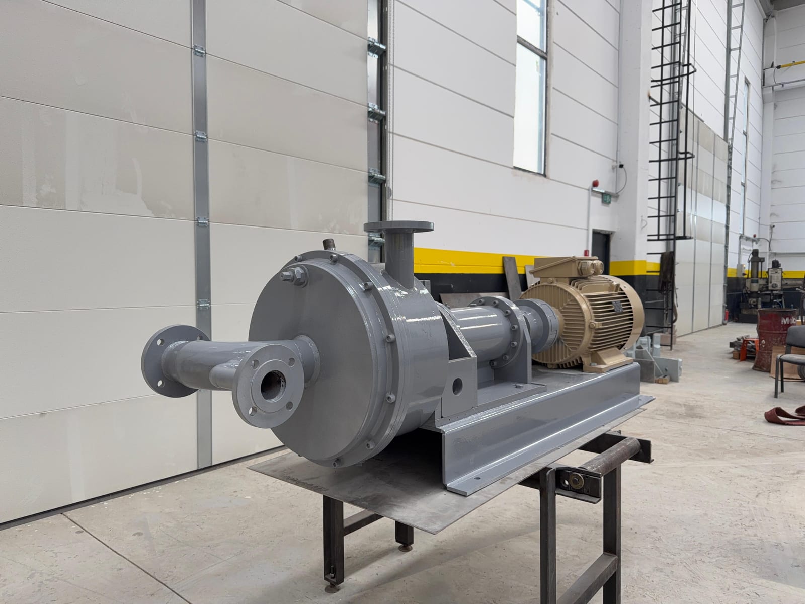 Front angle view of the asphalt emulsion plant mill: mill housing, inlet flanges and electric motor
